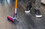 a-man-vacuums-the-floor-with-a-compact-vacuum-clea-web a-man-vacuums-the-floor-with-a-compact-vacuum-clea-web