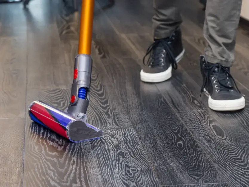 a-man-vacuums-the-floor-with-a-compact-vacuum-clea-web